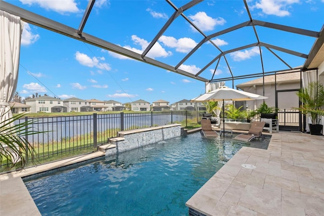 view of pool featuring a patio area, fence, a residential view, and a water view