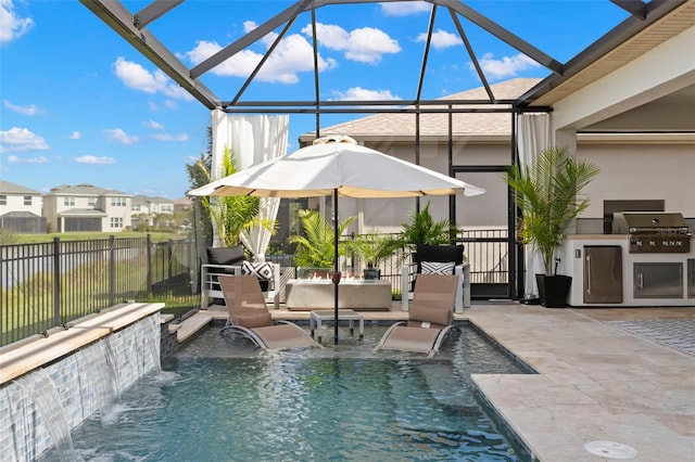 view of pool featuring a patio area, a grill, glass enclosure, and an outdoor kitchen