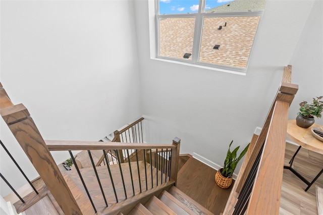 stairway with baseboards and wood finished floors