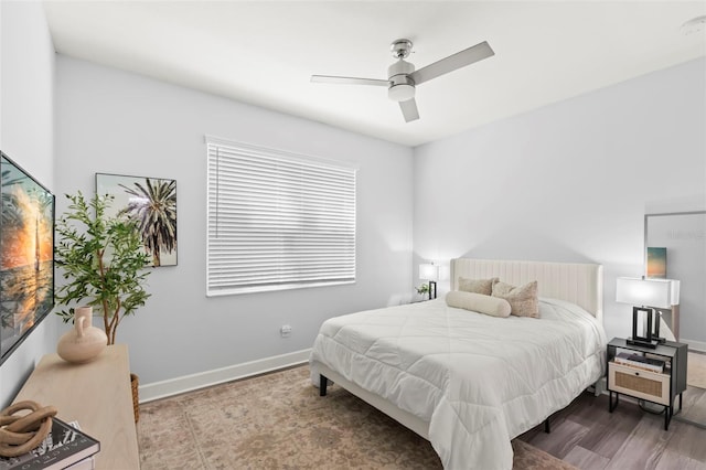 bedroom featuring a ceiling fan, baseboards, and wood finished floors