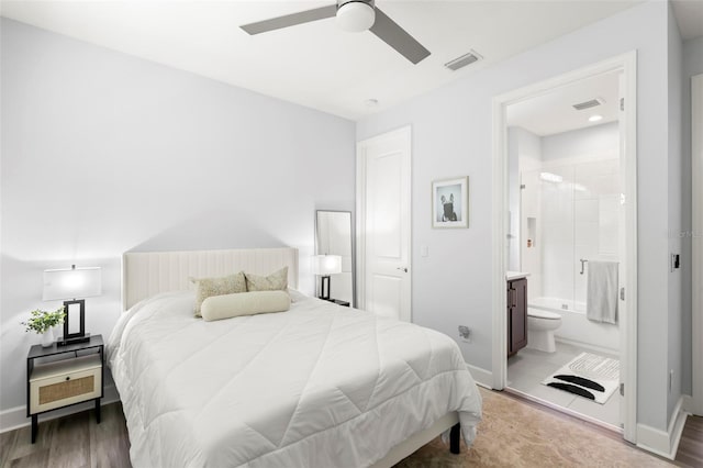 bedroom with ensuite bath, visible vents, and baseboards