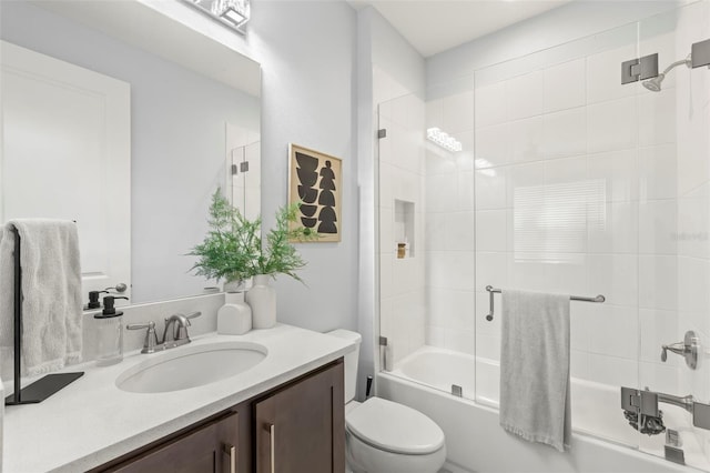 bathroom featuring toilet, shower / bath combination with glass door, and vanity