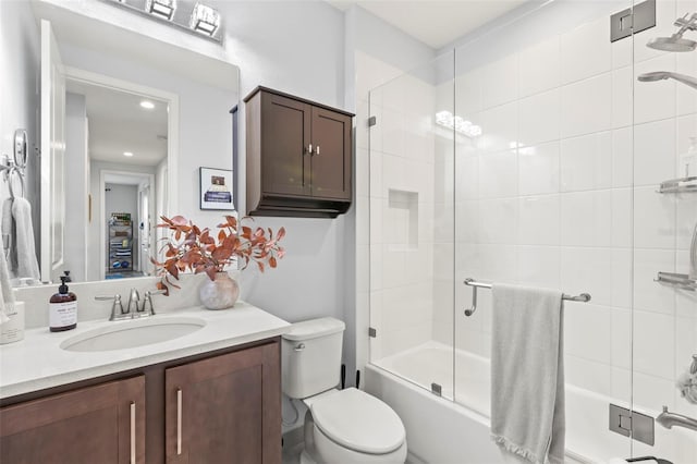 full bathroom featuring vanity, toilet, and bath / shower combo with glass door