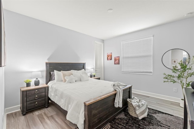 bedroom with light wood-type flooring and baseboards