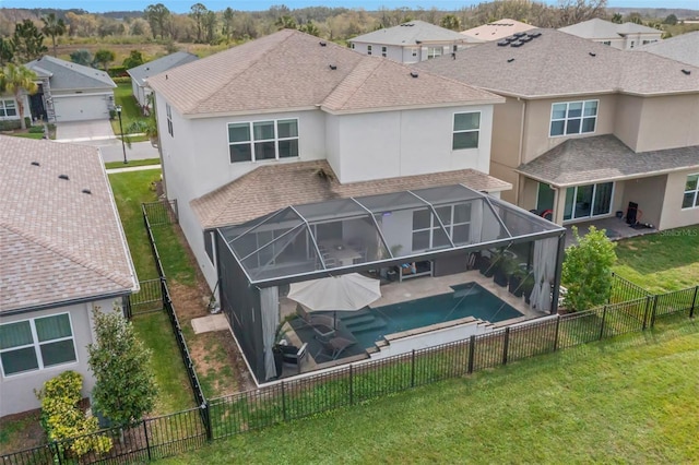 rear view of house with a patio, stucco siding, a shingled roof, a lanai, and a fenced backyard