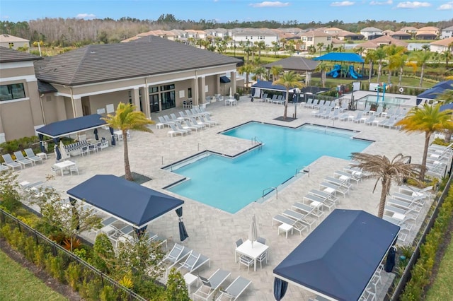 pool featuring a residential view, a patio, and fence