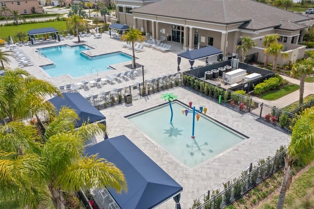 community pool with a patio area and fence