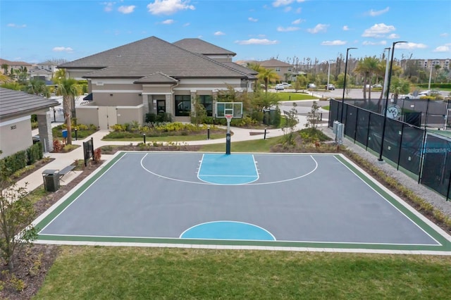 view of sport court with community basketball court, fence, and a yard