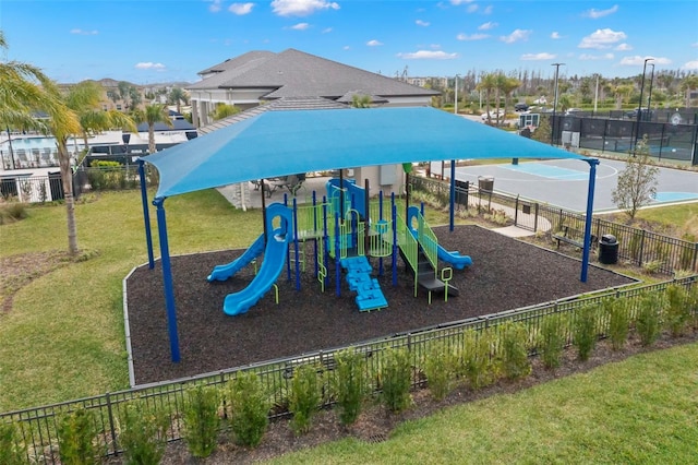 community play area with a yard and fence