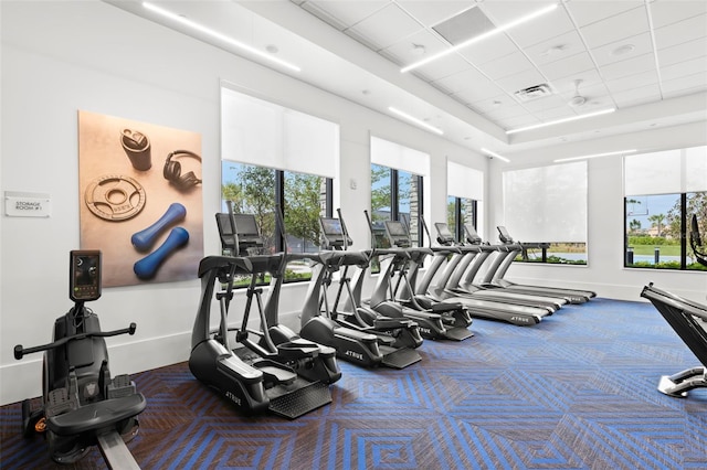 gym with a paneled ceiling, carpet, visible vents, and a wealth of natural light