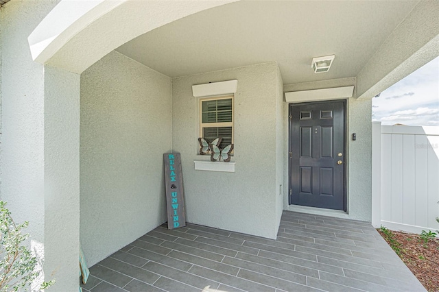 entrance to property with stucco siding