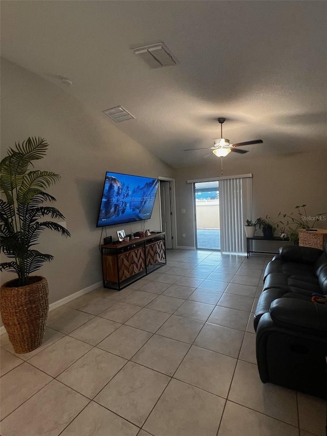 living area featuring light tile patterned floors, visible vents, baseboards, a ceiling fan, and a textured ceiling