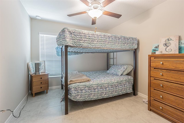 bedroom featuring light tile patterned flooring, a ceiling fan, and baseboards