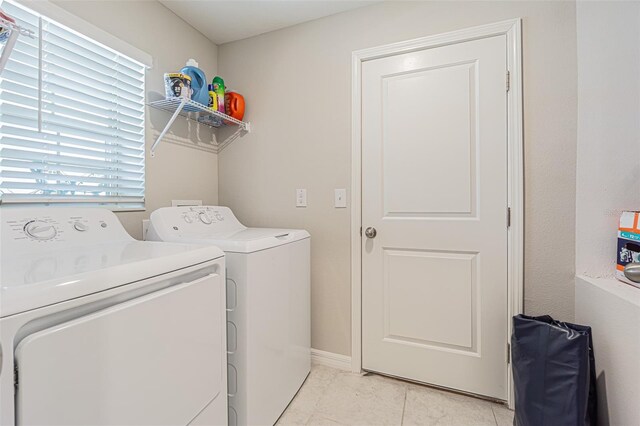 clothes washing area with laundry area, washer and clothes dryer, and baseboards