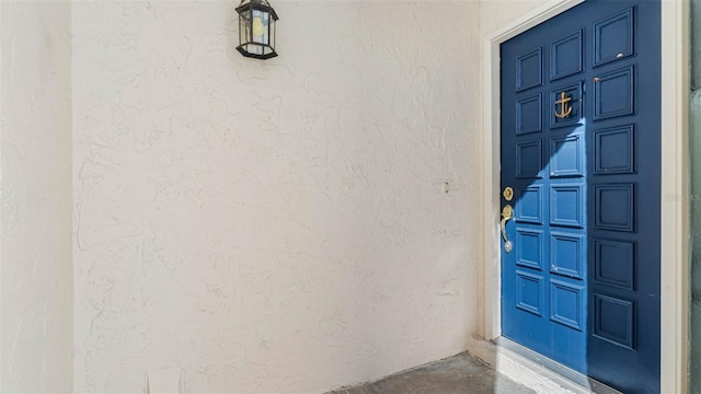 property entrance featuring a garage and stucco siding