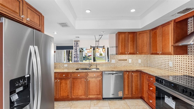 kitchen featuring brown cabinets, stainless steel appliances, a raised ceiling, visible vents, and a sink