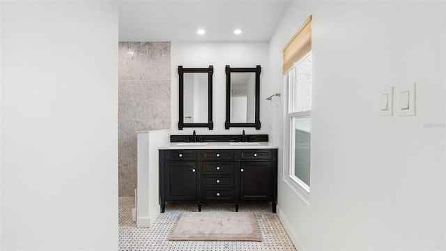 full bathroom featuring double vanity, walk in shower, a sink, and recessed lighting