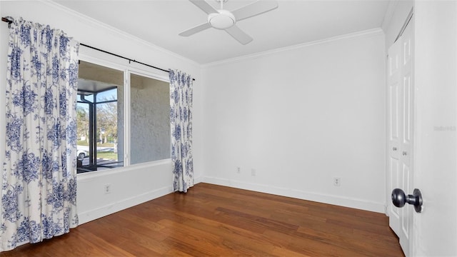 empty room featuring ornamental molding, ceiling fan, baseboards, and wood finished floors