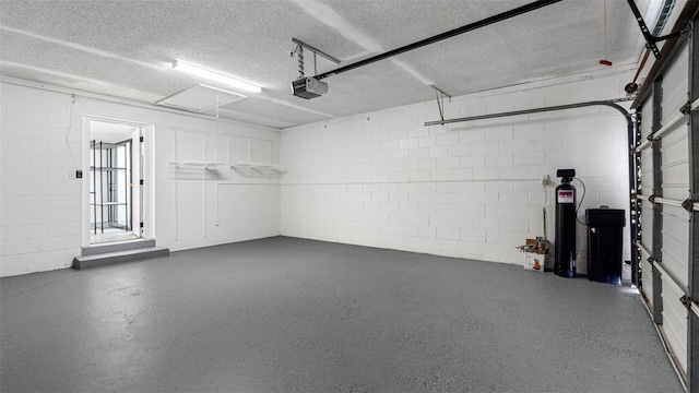 garage featuring concrete block wall and a garage door opener