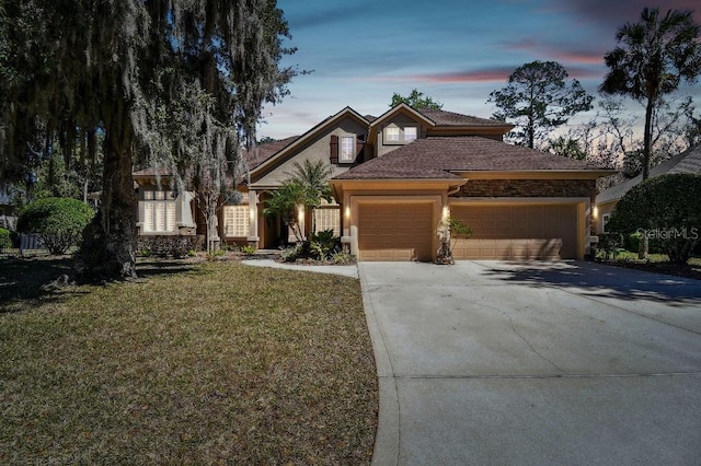 view of front of property featuring a yard, stucco siding, driveway, and a garage