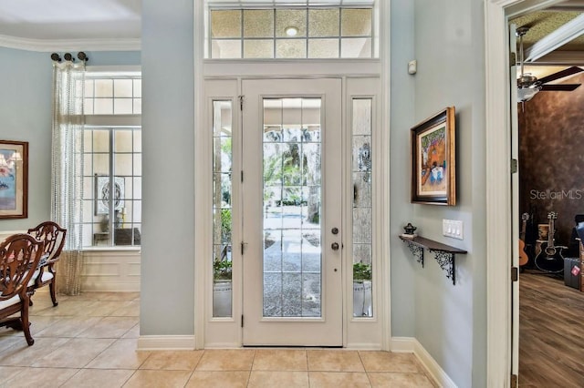 foyer featuring tile patterned flooring, crown molding, and baseboards