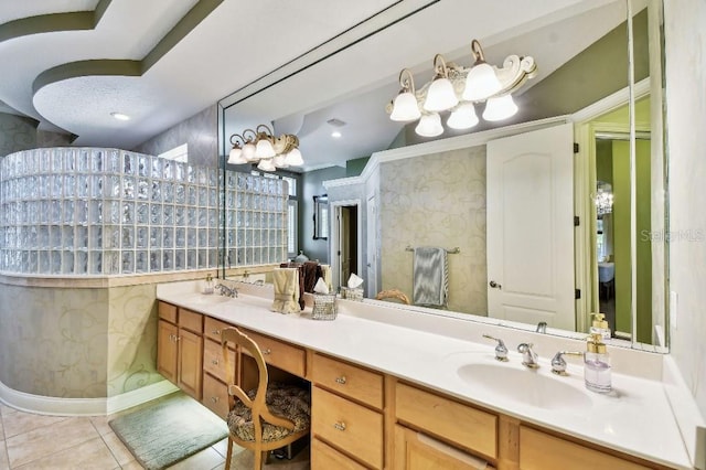 bathroom featuring a sink, double vanity, tile patterned flooring, and wallpapered walls