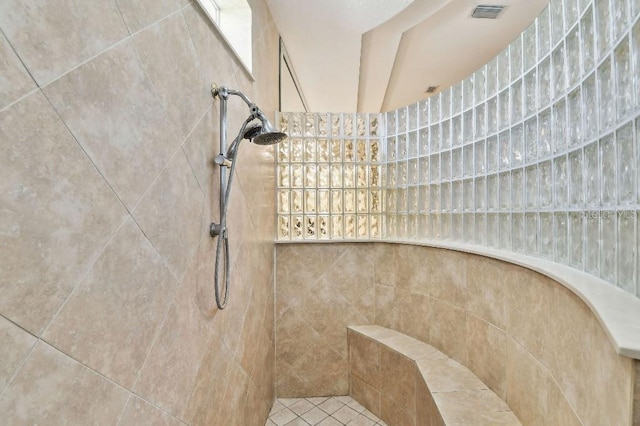 full bathroom featuring visible vents and tiled shower