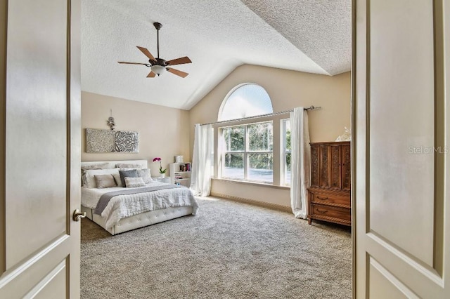 carpeted bedroom with lofted ceiling, a ceiling fan, and a textured ceiling