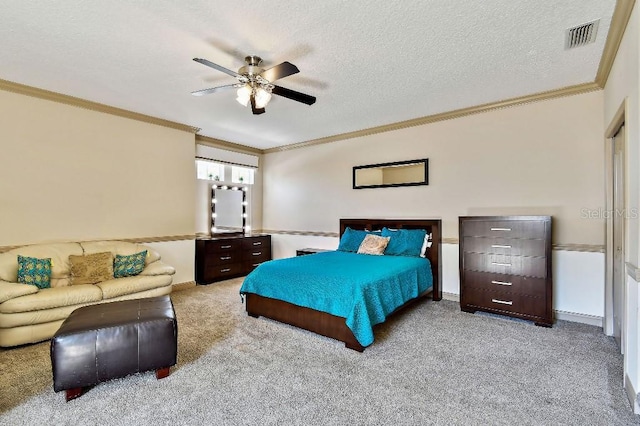 carpeted bedroom featuring visible vents, baseboards, ornamental molding, a textured ceiling, and a ceiling fan