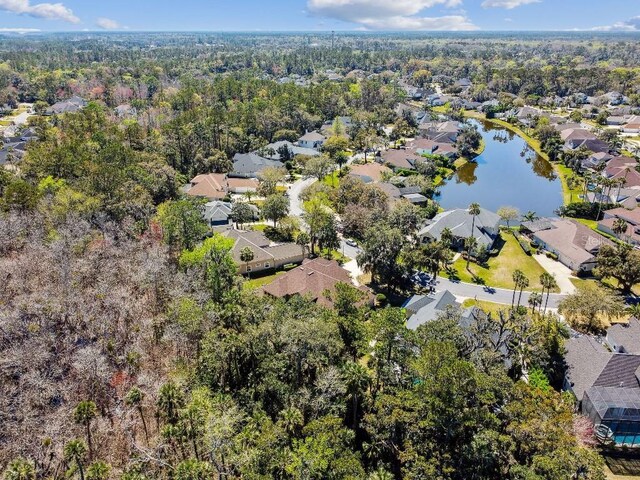 aerial view with a residential view, a wooded view, and a water view