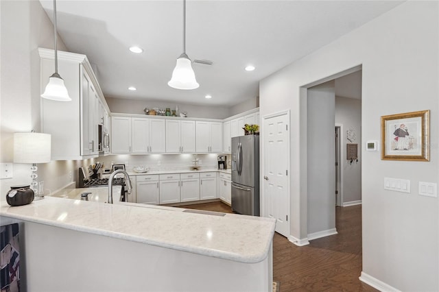 1467 Twin Villas Way, Dunedin, FL 34698 - kitchen with appliances with stainless steel finishes, a peninsula, dark wood-style floors, white cabinets, and decorative light fixtures