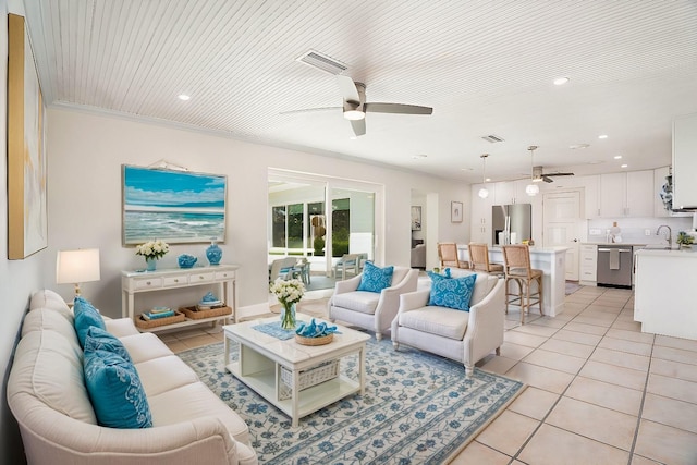 living area featuring ceiling fan, light tile patterned flooring, visible vents, and crown molding