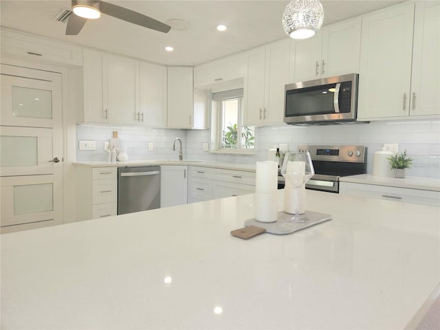 kitchen with a sink, decorative backsplash, stainless steel appliances, and light countertops