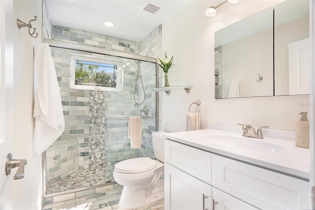 bathroom with visible vents, a shower stall, toilet, and vanity