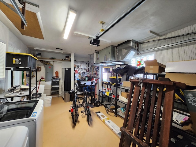 garage featuring washer / dryer, a workshop area, electric panel, and a garage door opener