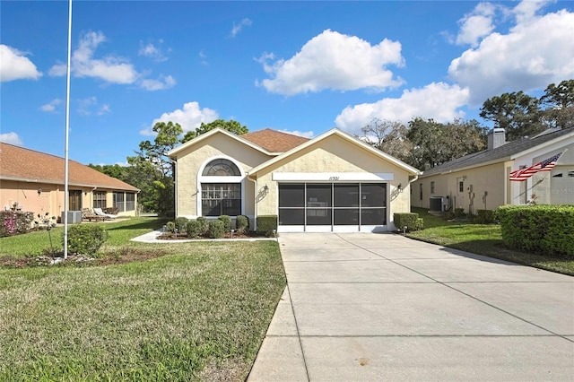 ranch-style home with central AC unit, a garage, driveway, stucco siding, and a front yard