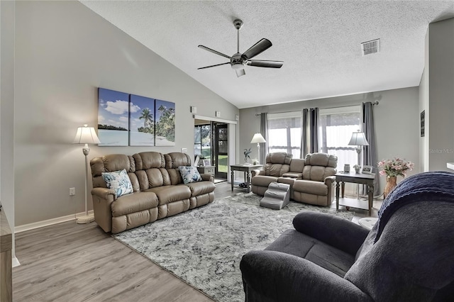 living room with baseboards, visible vents, a ceiling fan, wood finished floors, and a textured ceiling