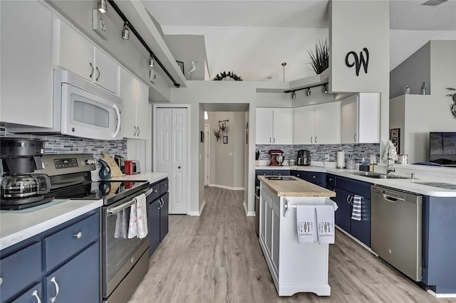 kitchen featuring stainless steel appliances, light countertops, and blue cabinets