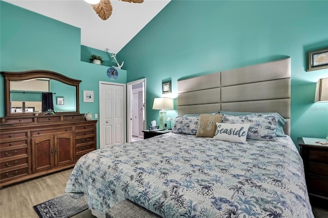 bedroom with high vaulted ceiling, a ceiling fan, and light wood-style floors