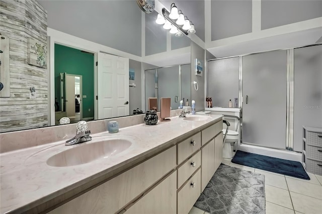 full bath with double vanity, a stall shower, tile patterned flooring, and a sink