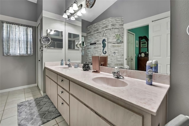 bathroom featuring double vanity, tile patterned flooring, a sink, and baseboards