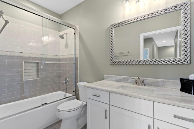 full bath featuring shower / bath combination with glass door, vanity, and toilet