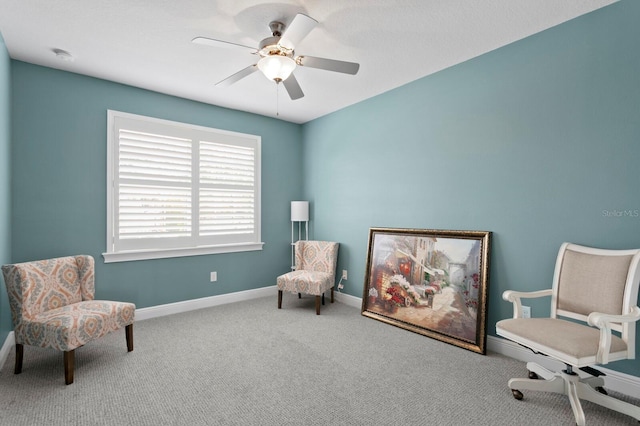 living area featuring carpet, baseboards, and ceiling fan