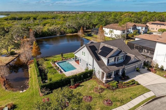 birds eye view of property with a water view and a view of trees