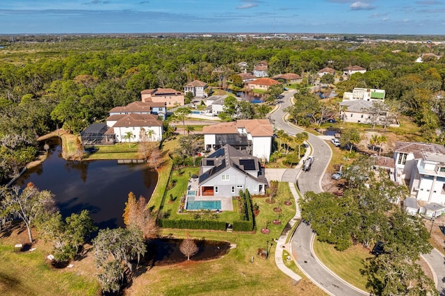 bird's eye view featuring a residential view, a water view, and a wooded view