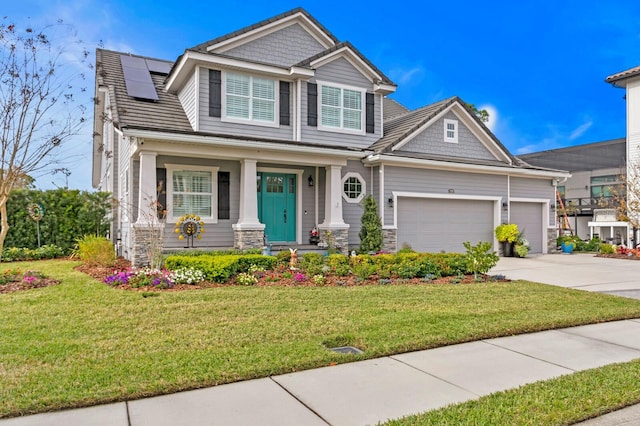 craftsman-style house with a front yard, concrete driveway, an attached garage, and solar panels