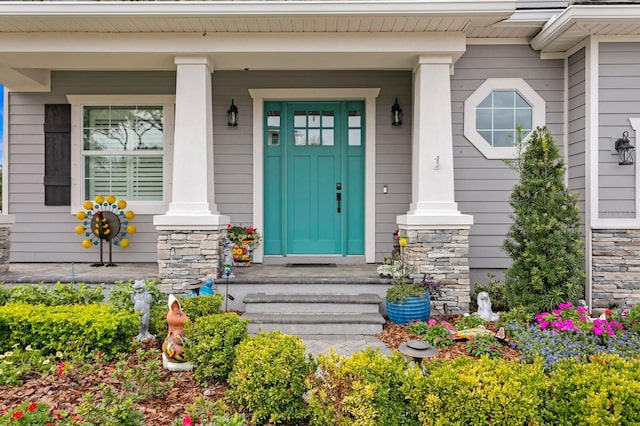 entrance to property featuring stone siding and a porch