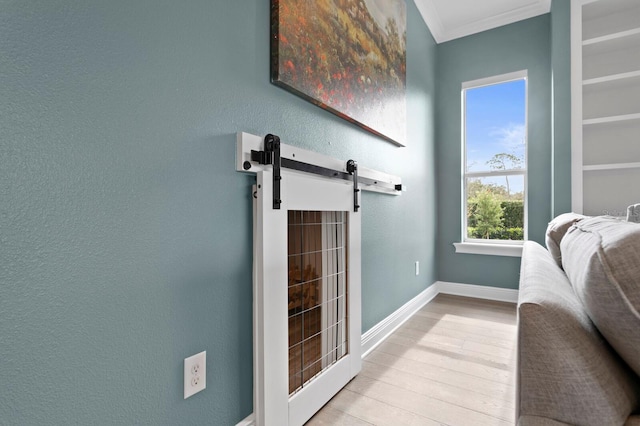 interior space featuring baseboards, crown molding, and wood finished floors