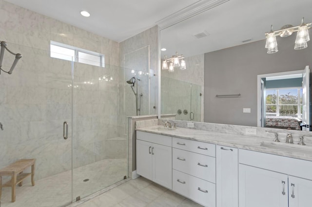 ensuite bathroom featuring a sink, double vanity, a shower stall, and visible vents