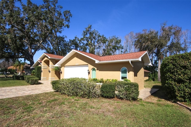 view of front facade featuring a front yard, driveway, and stucco siding